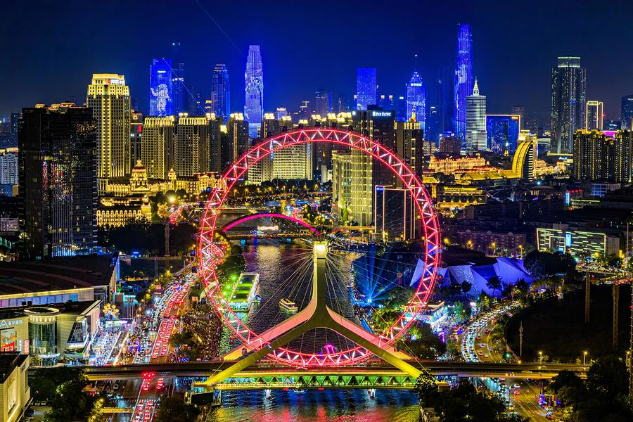 An aerial drone photo taken on Aug. 25, 2025 shows a light show along the Haihe River in north China's Tianjin. (Photo by Du Penghui/Xinhua)
