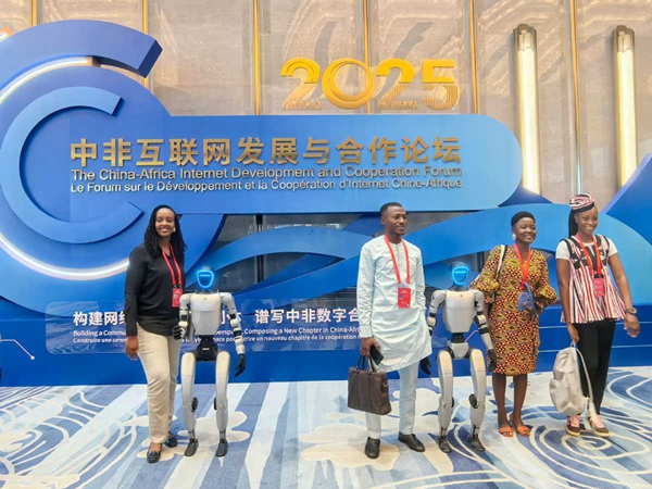 Participants pose for a photo with humanoid robots at the opening ceremony of the China-Africa Internet Development and Cooperation Forum, in Xiamen, Southeast China's Fujian province, on Sept 28. [Photo by Dong Xinyi/chinadaily.com.cn]